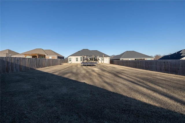 1355 NE Pershing St, Fayetteville, AR 72704 - rear view of property featuring a trampoline and a fenced backyard