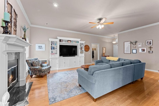 1409 S Breckenridge Loop, Rogers, AR 72756 - living area with a premium fireplace, a ceiling fan, light wood-style floors, and crown molding