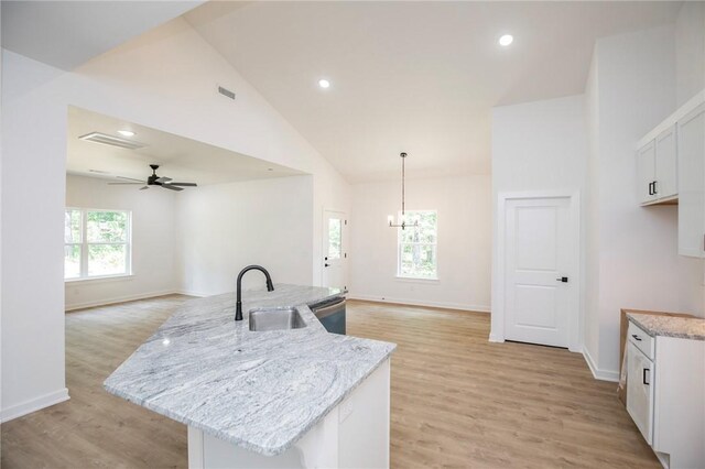 7 Consett Ln, Bella Vista, AR 72714 - kitchen featuring stainless steel dishwasher, open floor plan, high vaulted ceiling, light wood-style floors, and light stone countertops