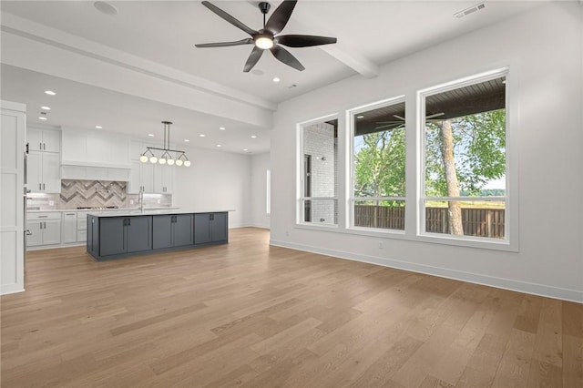 8607 W Feathered Nest Run, Bentonville, AR 72713 - unfurnished living room featuring light wood-type flooring, a ceiling fan, beamed ceiling, recessed lighting, and a chandelier