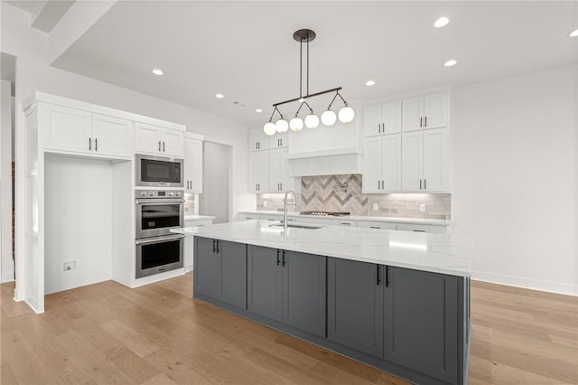 8607 W Feathered Nest Run, Bentonville, AR 72713 - kitchen featuring appliances with stainless steel finishes, white cabinets, light wood finished floors, backsplash, and recessed lighting