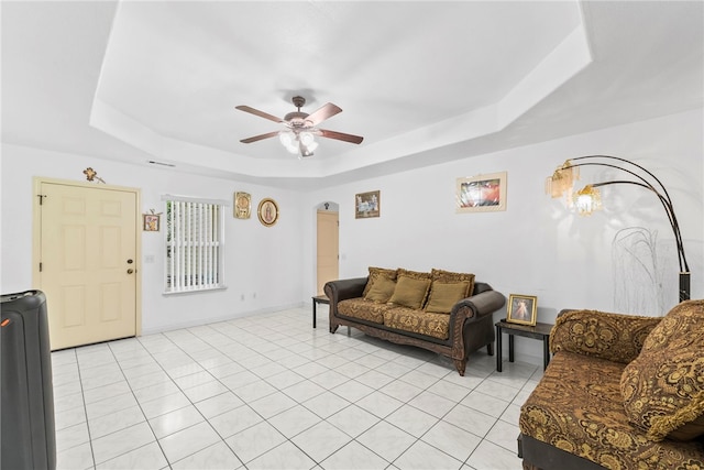 2302 12th Pl, Rogers, AR 72758 - living room with a tray ceiling, arched walkways, ceiling fan, and light tile patterned floors