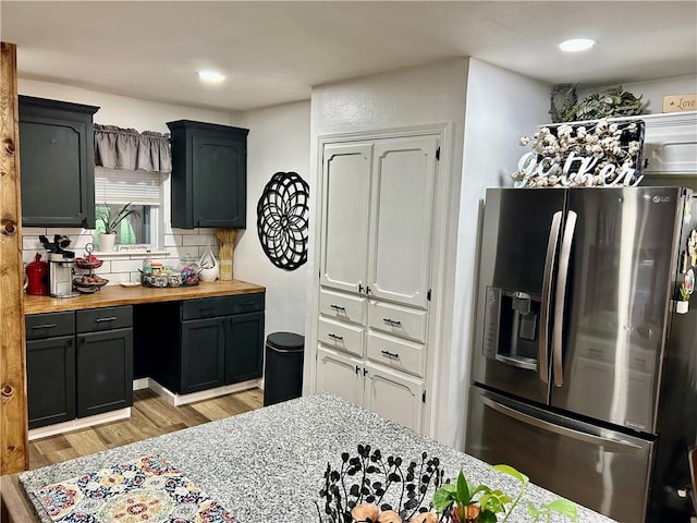 3383 Sr 164 E, Dover, AR 72837 - kitchen featuring stainless steel refrigerator with ice dispenser, light wood-style flooring, decorative backsplash, recessed lighting, and butcher block countertops