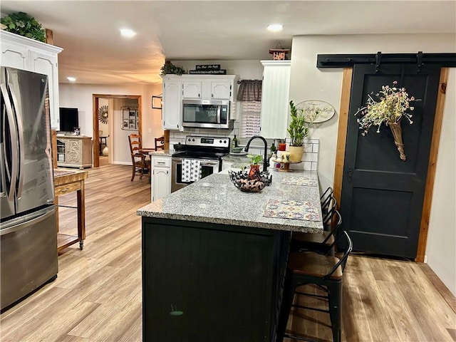 3383 Sr 164 E, Dover, AR 72837 - kitchen featuring stainless steel appliances, a peninsula, white cabinets, a breakfast bar, and recessed lighting