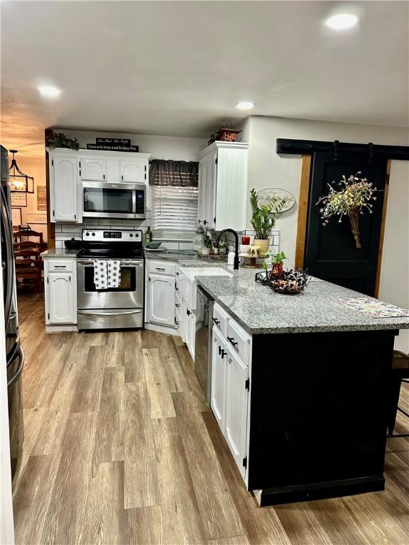 3383 Sr 164 E, Dover, AR 72837 - kitchen featuring appliances with stainless steel finishes, a peninsula, white cabinets, light stone counters, and recessed lighting