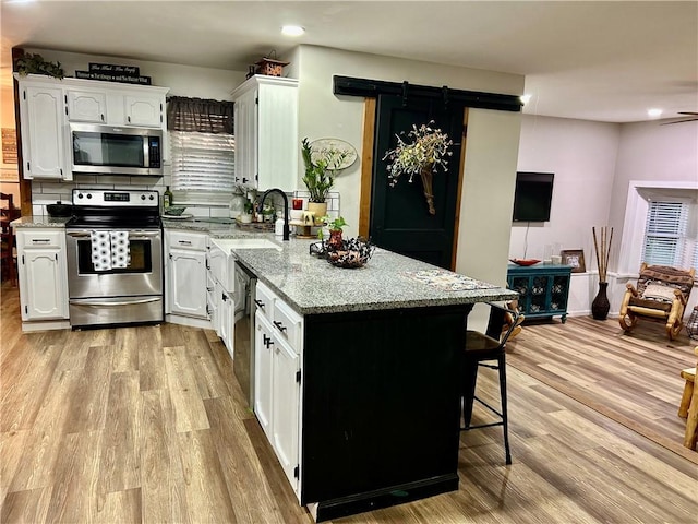 3383 Sr 164 E, Dover, AR 72837 - kitchen with appliances with stainless steel finishes, white cabinetry, a peninsula, light wood finished floors, and recessed lighting
