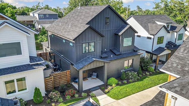 103 NW Ozark Way, Bentonville, AR 72712 - rear view of house with board and batten siding, roof with shingles, a patio, and brick siding