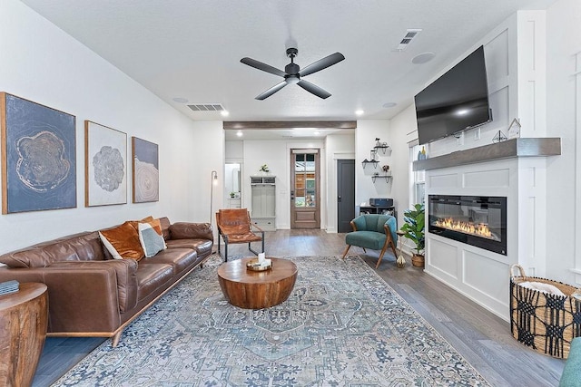 103 NW Ozark Way, Bentonville, AR 72712 - living area featuring wood finished floors, ceiling fan, and a glass covered fireplace
