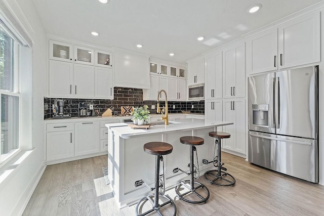 103 NW Ozark Way, Bentonville, AR 72712 - kitchen with appliances with stainless steel finishes, light wood-style floors, backsplash, white cabinetry, and recessed lighting