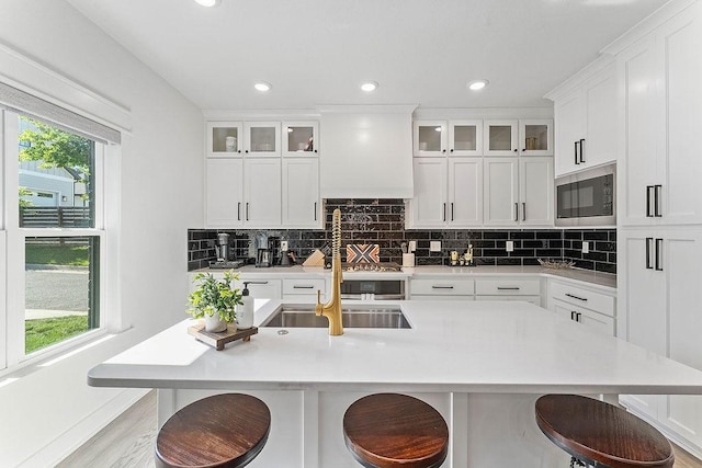 103 NW Ozark Way, Bentonville, AR 72712 - kitchen with stainless steel microwave, light countertops, backsplash, a kitchen bar, and recessed lighting
