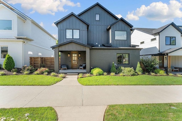 103 NW Ozark Way, Bentonville, AR 72712 - view of front of home with board and batten siding, a porch, and a front lawn