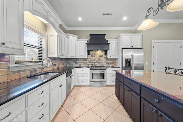 4130 Willowbend Dr, Rogers, AR 72758 - kitchen with stainless steel appliances, custom exhaust hood, white cabinets, dark stone counters, and backsplash