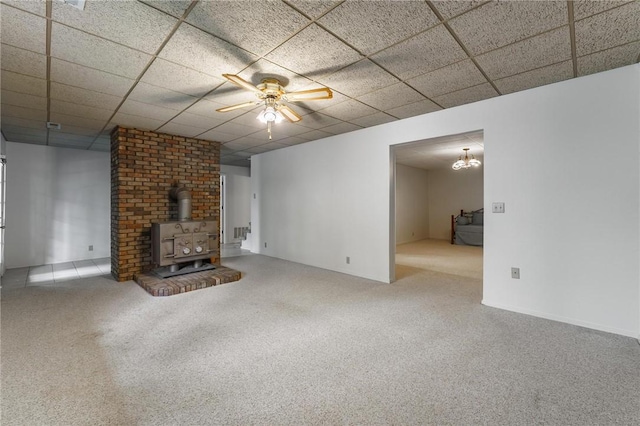 8394 Admiral Nimitz Dr, Rogers, AR 72756 - unfurnished living room with a wood stove, carpet floors, ceiling fan, and a paneled ceiling