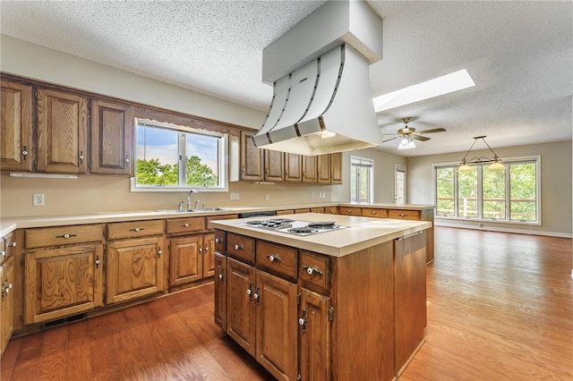 8394 Admiral Nimitz Dr, Rogers, AR 72756 - kitchen with white cooktop, a skylight, a textured ceiling, light countertops, and wood finished floors