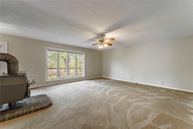 8394 Admiral Nimitz Dr, Rogers, AR 72756 - unfurnished living room with carpet, a ceiling fan, a wood stove, and a textured ceiling
