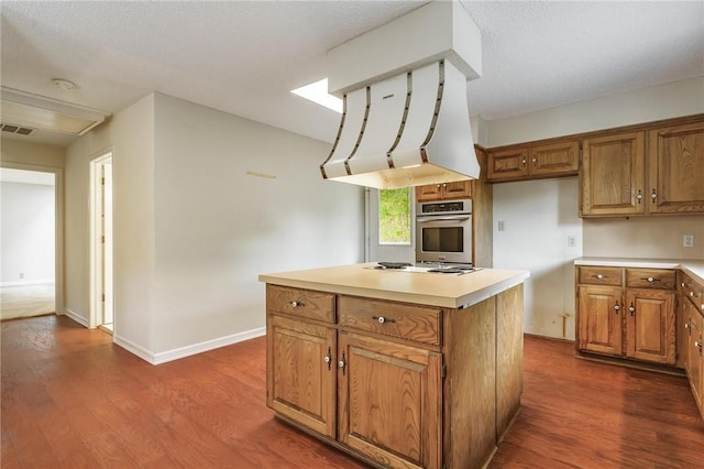 8394 Admiral Nimitz Dr, Rogers, AR 72756 - kitchen with stainless steel oven, brown cabinets, dark wood-type flooring, and a kitchen island