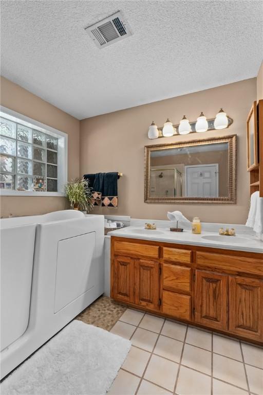 2105 Brookhaven Dr, Alma, AR 72921 - full bath with double vanity, a shower with door, and a textured ceiling
