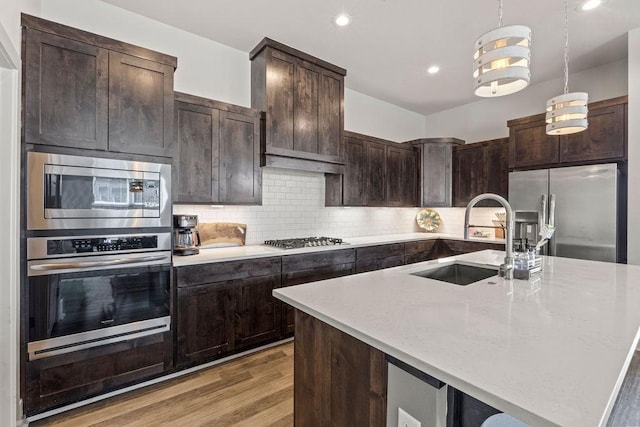 1428 Allens Mill Way, Cave Springs, AR 72718 - kitchen featuring appliances with stainless steel finishes, light wood-style flooring, dark brown cabinets, backsplash, and decorative light fixtures