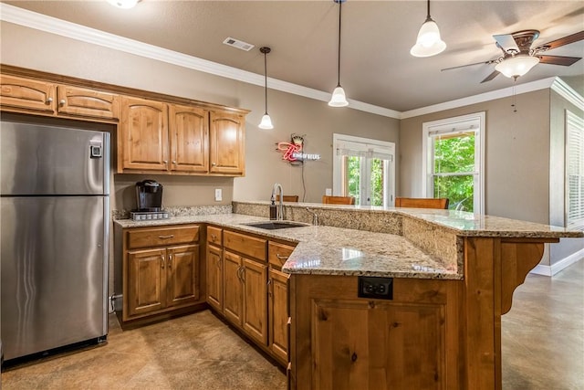 348 Whitcliff Dr, Cave Springs, AR 72718 - kitchen featuring freestanding refrigerator, a peninsula, a ceiling fan, brown cabinetry, and a kitchen bar