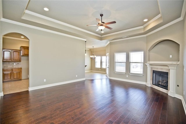 145 Rosemeade Dr, Farmington, AR 72730 - unfurnished living room with a tray ceiling, ceiling fan, a glass covered fireplace, wood finished floors, and crown molding