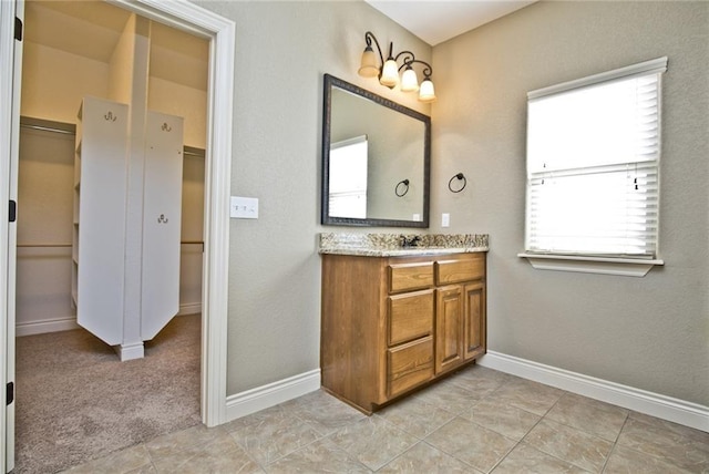 145 Rosemeade Dr, Farmington, AR 72730 - full bathroom featuring vanity, a walk in closet, and tile patterned flooring