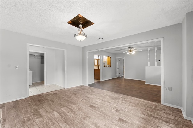 603 Thomas Blvd, Springdale, AR 72762 - unfurnished living room featuring wood finished floors, a ceiling fan, and a textured ceiling