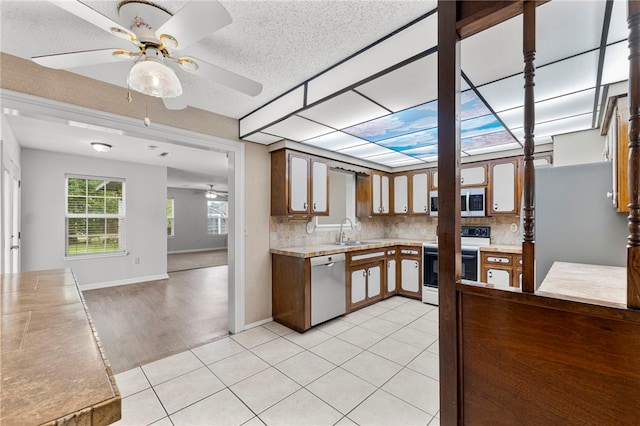 603 Thomas Blvd, Springdale, AR 72762 - kitchen featuring appliances with stainless steel finishes, a ceiling fan, light countertops, backsplash, and a textured ceiling