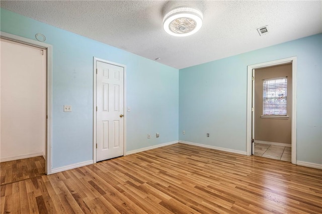 3103 Levi Ln, Bentonville, AR 72712 - unfurnished bedroom with wood finished floors and a textured ceiling