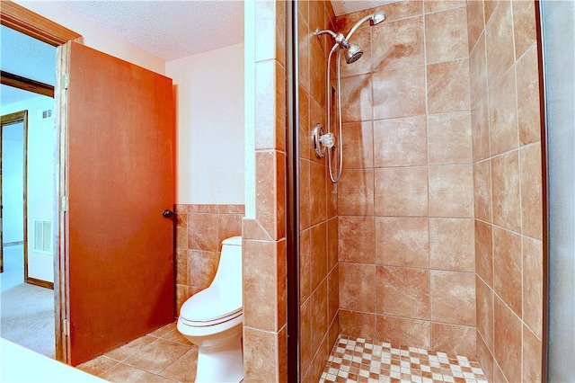 19135 Shoreline Way, Fayetteville, AR 72703 - full bathroom featuring a textured ceiling, tiled shower, tile patterned floors, tile walls, and a wainscoted wall