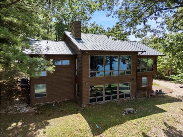 188 Point Mirage Rd, Eureka Springs, AR 72631 - rear view of house featuring a chimney, a lawn, a standing seam roof, and a metal roof