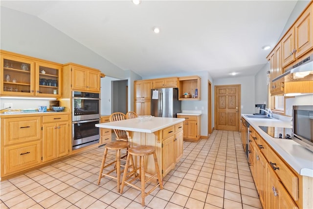 188 Point Mirage Rd, Eureka Springs, AR 72631 - kitchen with stainless steel appliances, vaulted ceiling, a breakfast bar area, a kitchen island, and light tile patterned floors