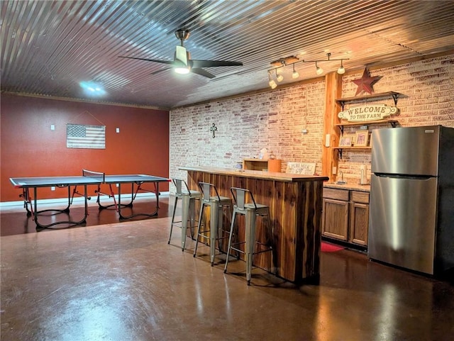 1445 Woodhaven Ln, Harrison, AR 72601 - community bar area with freestanding refrigerator, concrete flooring, ceiling fan, and brick wall