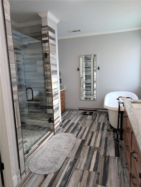 1445 Woodhaven Ln, Harrison, AR 72601 - full bathroom with vanity, a stall shower, crown molding, a freestanding bath, and wood finished floors