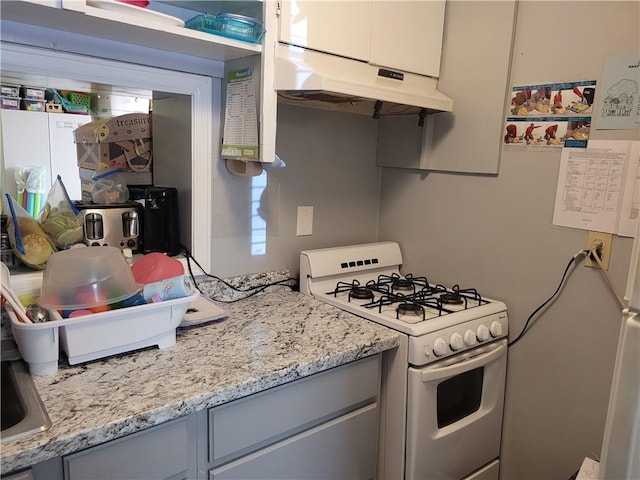 400 Franklin St, Harrison, AR 72601 - kitchen featuring white range with gas stovetop, under cabinet range hood, gray cabinetry, and light stone counters