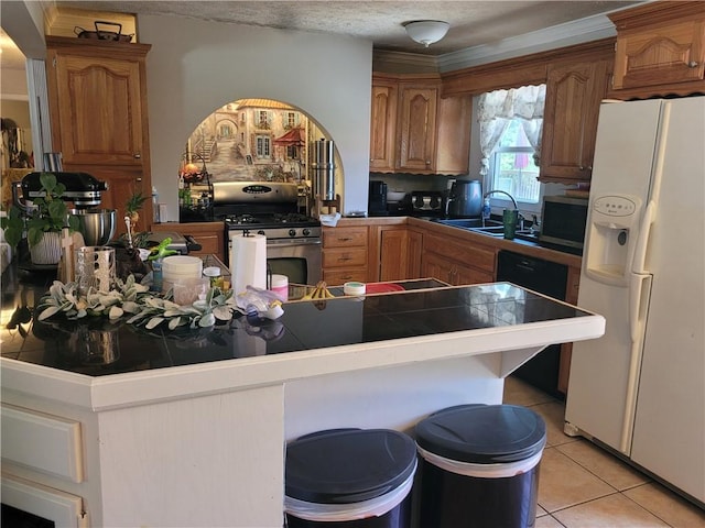 400 Franklin St, Harrison, AR 72601 - kitchen featuring appliances with stainless steel finishes, tile countertops, light tile patterned floors, a breakfast bar area, and brown cabinets