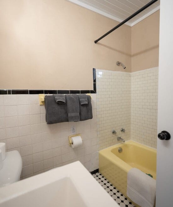 151 W Van Buren, Eureka Springs, AR 72632 - bathroom featuring shower / bathtub combination, tile walls, crown molding, and a wainscoted wall
