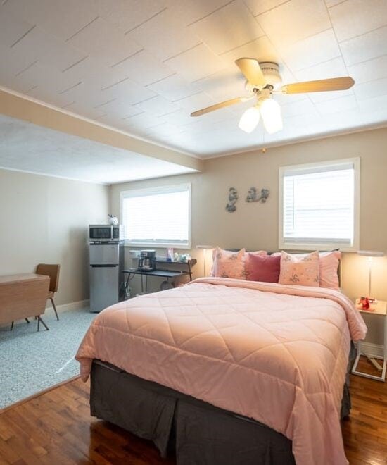 151 W Van Buren, Eureka Springs, AR 72632 - bedroom with freestanding refrigerator, wood finished floors, and ceiling fan