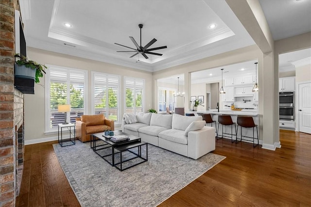 1200 Birkshire Cir, Cave Springs, AR 72718 - living room with a raised ceiling, a ceiling fan, ornamental molding, a fireplace, and dark wood finished floors