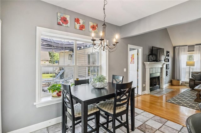 1112 N Oriole Ave, Rogers, AR 72756 - dining space featuring a chandelier, a tiled fireplace, and vaulted ceiling
