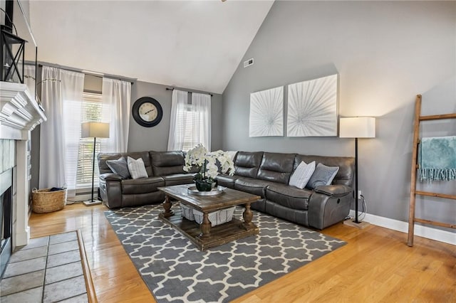 1112 N Oriole Ave, Rogers, AR 72756 - living room with a fireplace with flush hearth, high vaulted ceiling, and light wood-style flooring