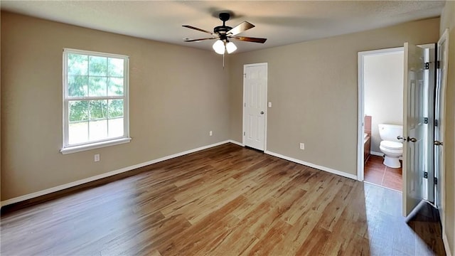 3107 SW Wentworth Ave, Bentonville, AR 72713 - unfurnished bedroom featuring wood finished floors, ensuite bath, and ceiling fan