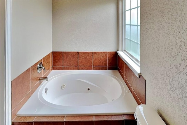 3107 SW Wentworth Ave, Bentonville, AR 72713 - full bath featuring a jetted tub, plenty of natural light, and a textured wall