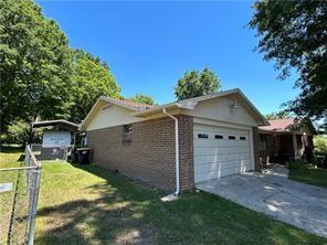 411 Natchez Trace St, Harrison, AR 72601 - view of side of property featuring an attached garage, concrete driveway, brick siding, and a lawn