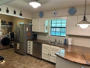 411 Natchez Trace St, Harrison, AR 72601 - kitchen featuring washer / clothes dryer, appliances with stainless steel finishes, white cabinets, pendant lighting, and dark countertops