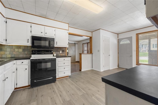702 E Argyle, Harrison, AR 72601 - kitchen featuring black microwave, range with electric cooktop, dark countertops, decorative backsplash, and white cabinetry