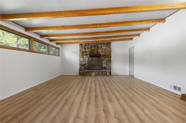 702 E Argyle, Harrison, AR 72601 - unfurnished living room with beam ceiling, light wood-style floors, and a stone fireplace