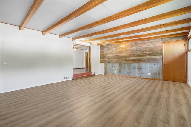 702 E Argyle, Harrison, AR 72601 - unfurnished room with wood walls, beamed ceiling, wood finished floors, and ceiling fan