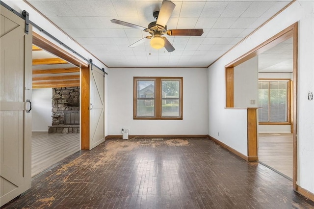 702 E Argyle, Harrison, AR 72601 - unfurnished room with a barn door, hardwood / wood-style floors, healthy amount of natural light, and ceiling fan