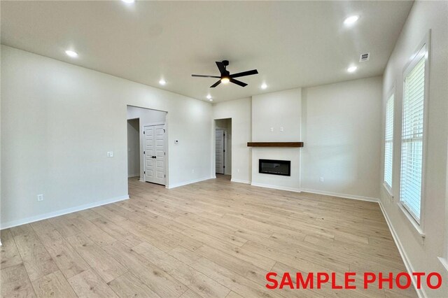 5906 SW Chiefs Rd, Bentonville, AR 72713 - unfurnished living room with ceiling fan, recessed lighting, light wood-style floors, and a glass covered fireplace