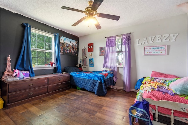 9402 Stone Ln, Omaha, AR 72662 - bedroom with dark wood-style floors, multiple windows, a textured ceiling, and ceiling fan
